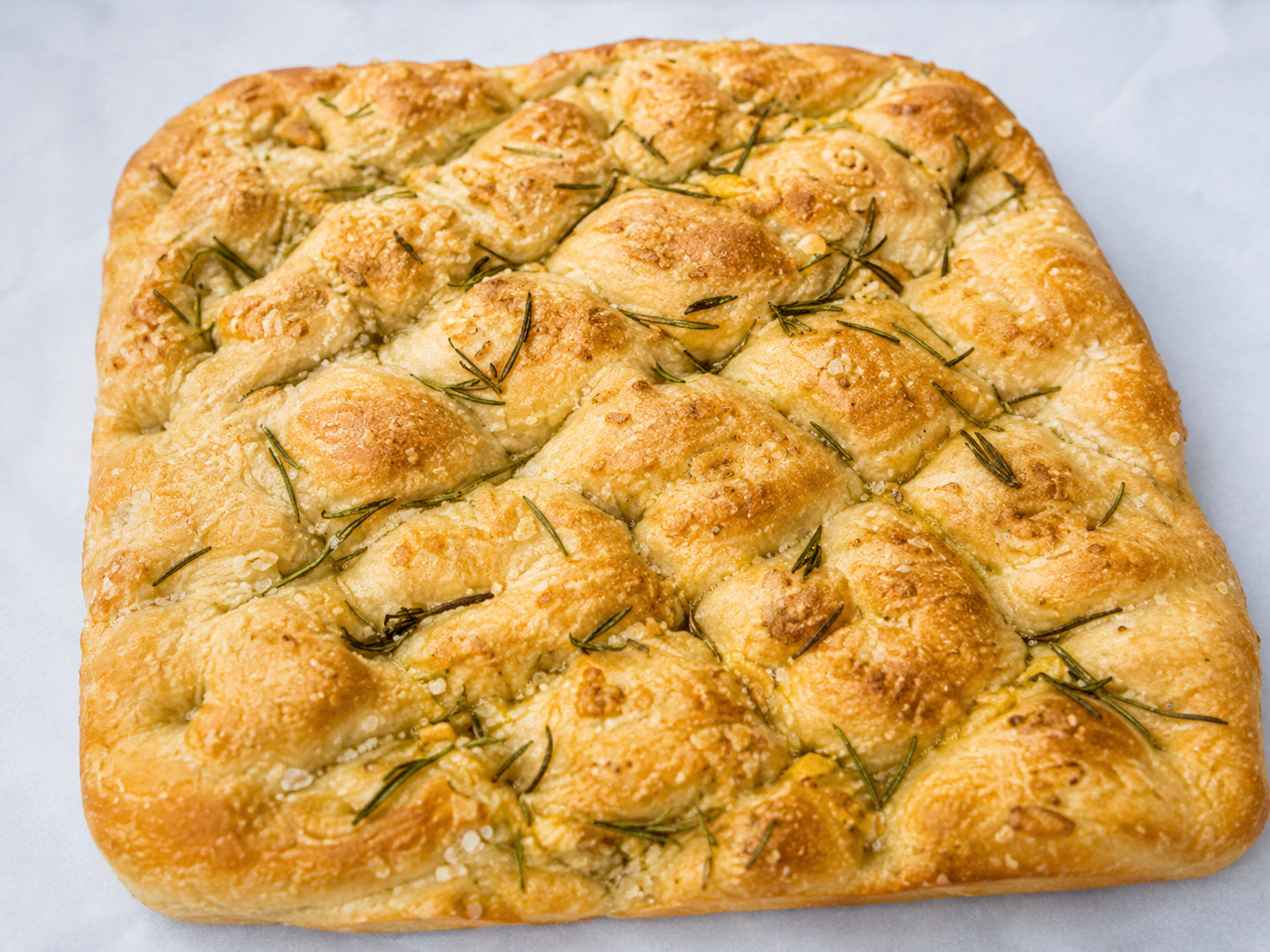 Focaccia de Alecrim da Padoca da Joy, com azeite brilhante na superfície, alecrim fresco e acabamento dourado