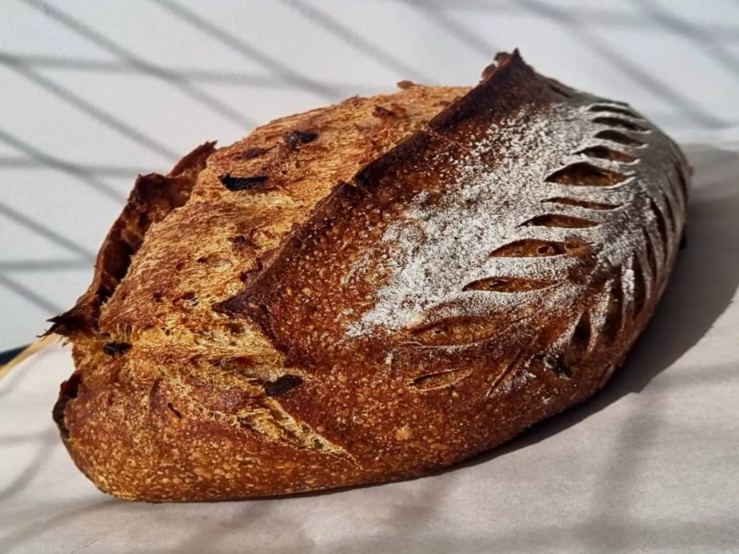 Sourdough Cerveja e Bacon da Padoca da Joy, com casca escura e crocante, toque defumado e sabor marcante